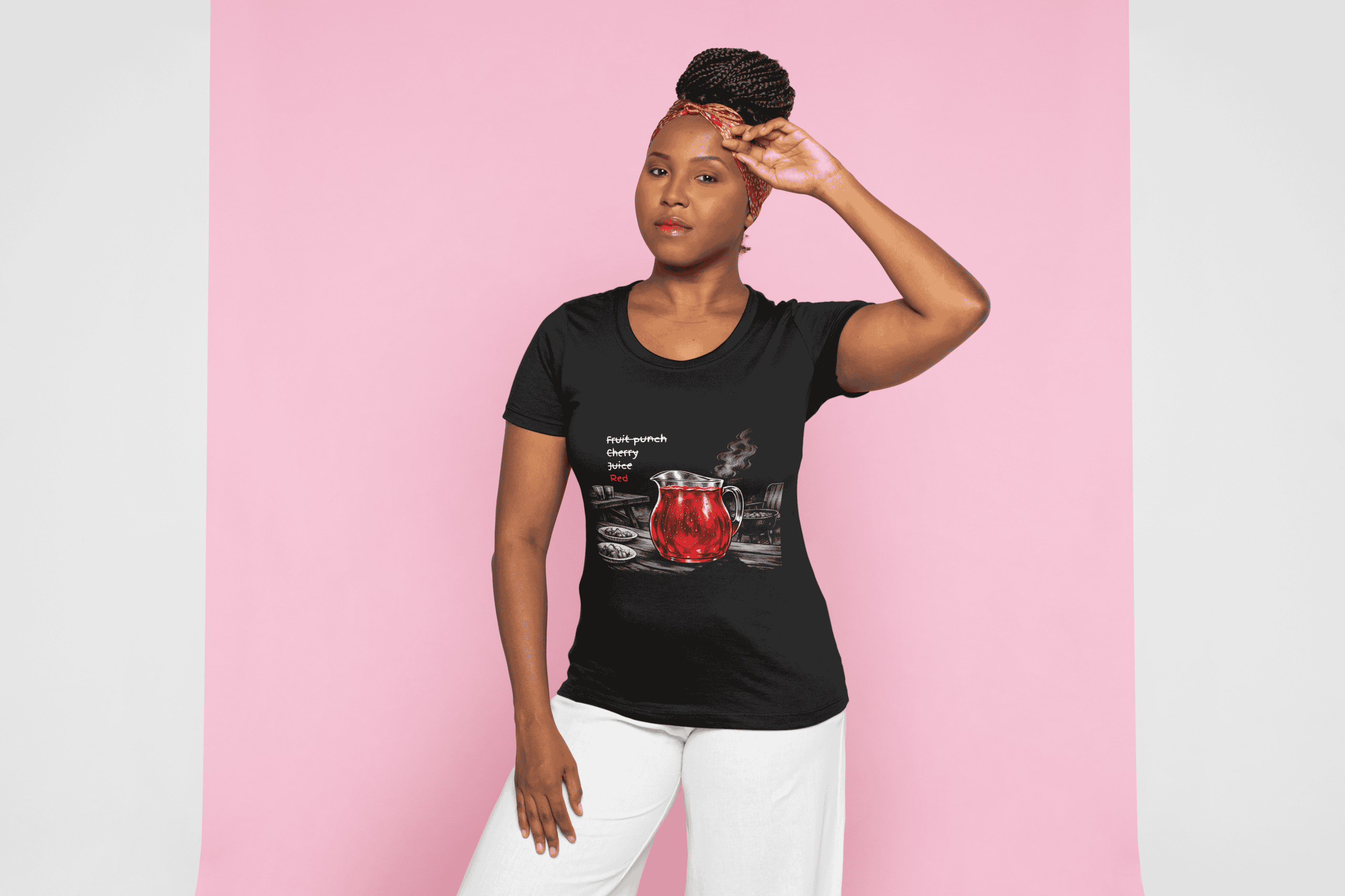 Woman wearing a black Cousins Dozens T-shirt with fruit graphic, standing against pink background.