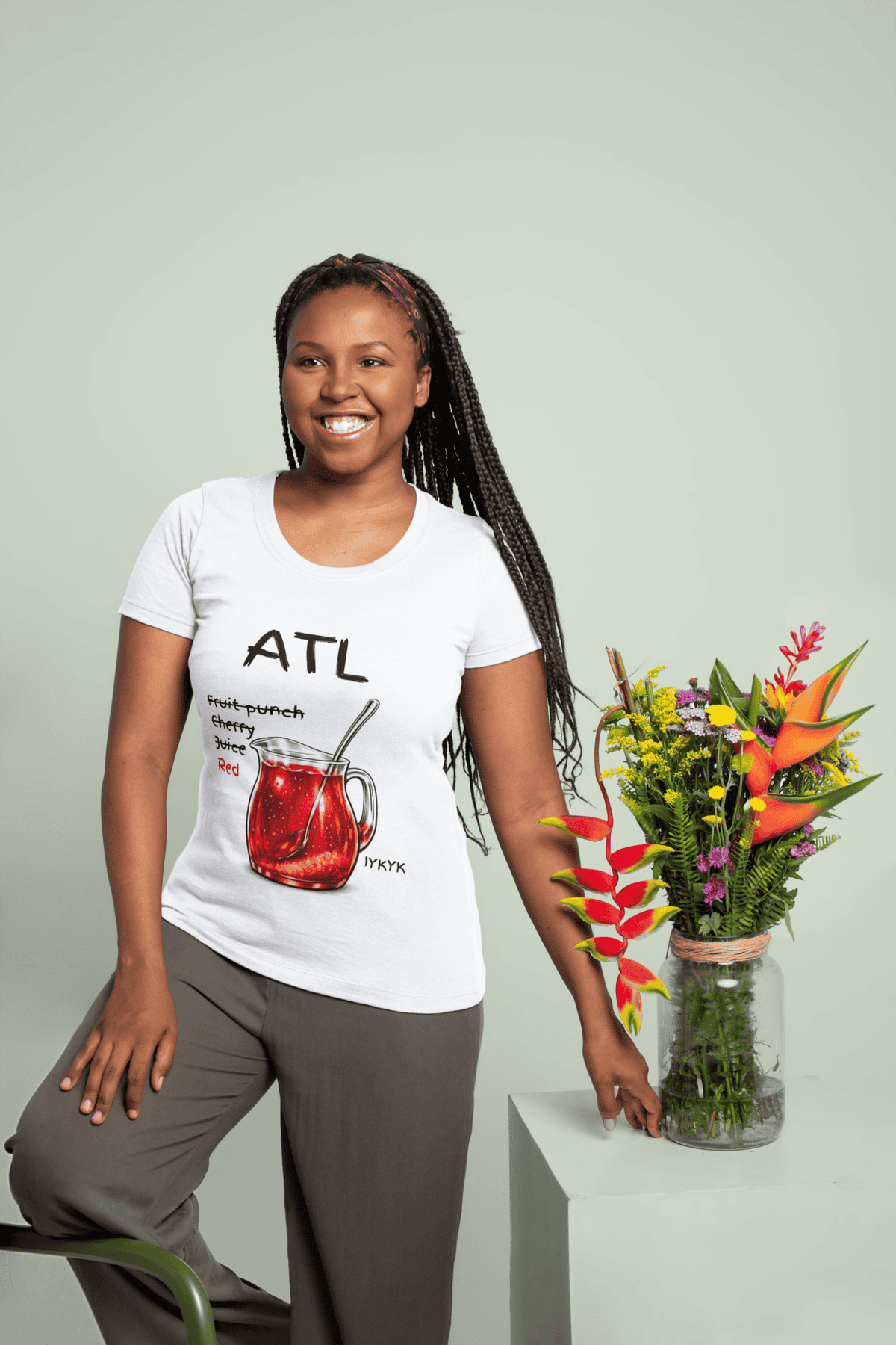 Bright floral arrangement with colorful flowers and tropical leaves, held by a smiling woman in casu.