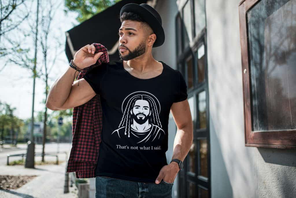 Young man wearing Cousins Dozens T-shirt with Jesus graphic outdoors.
