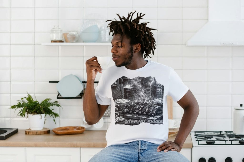 Young man enjoying coffee in a bright, modern kitchen setting.
