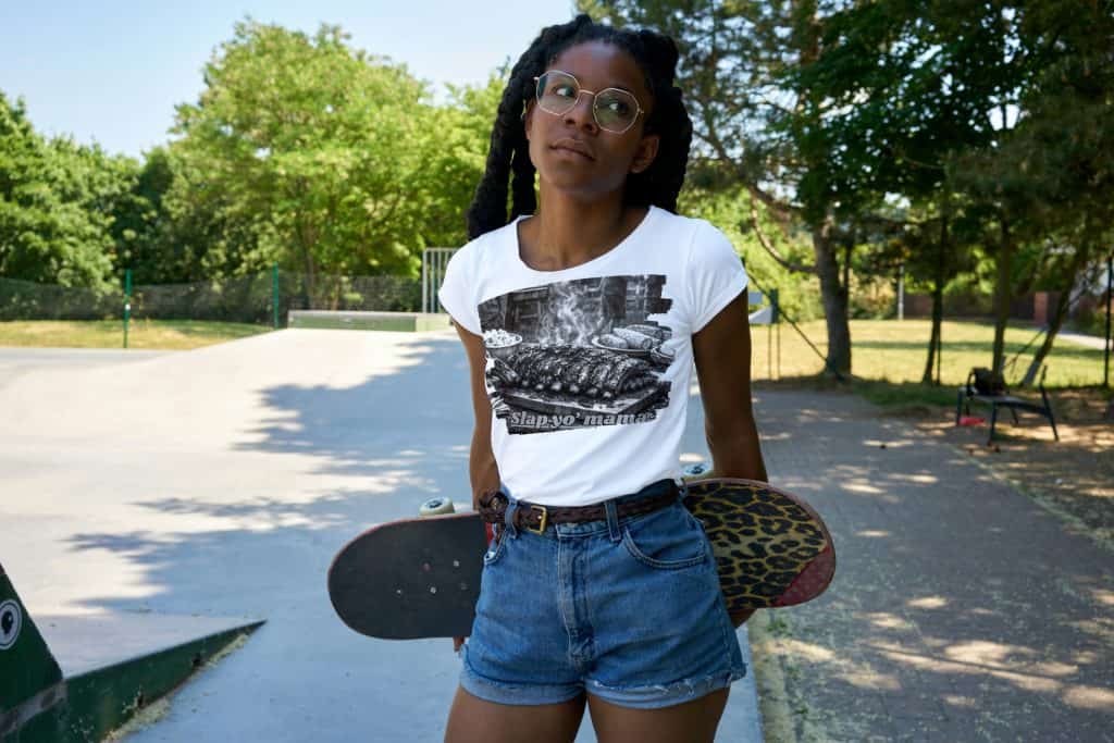 Girl with skateboard at park, enjoying skateboarding activity.