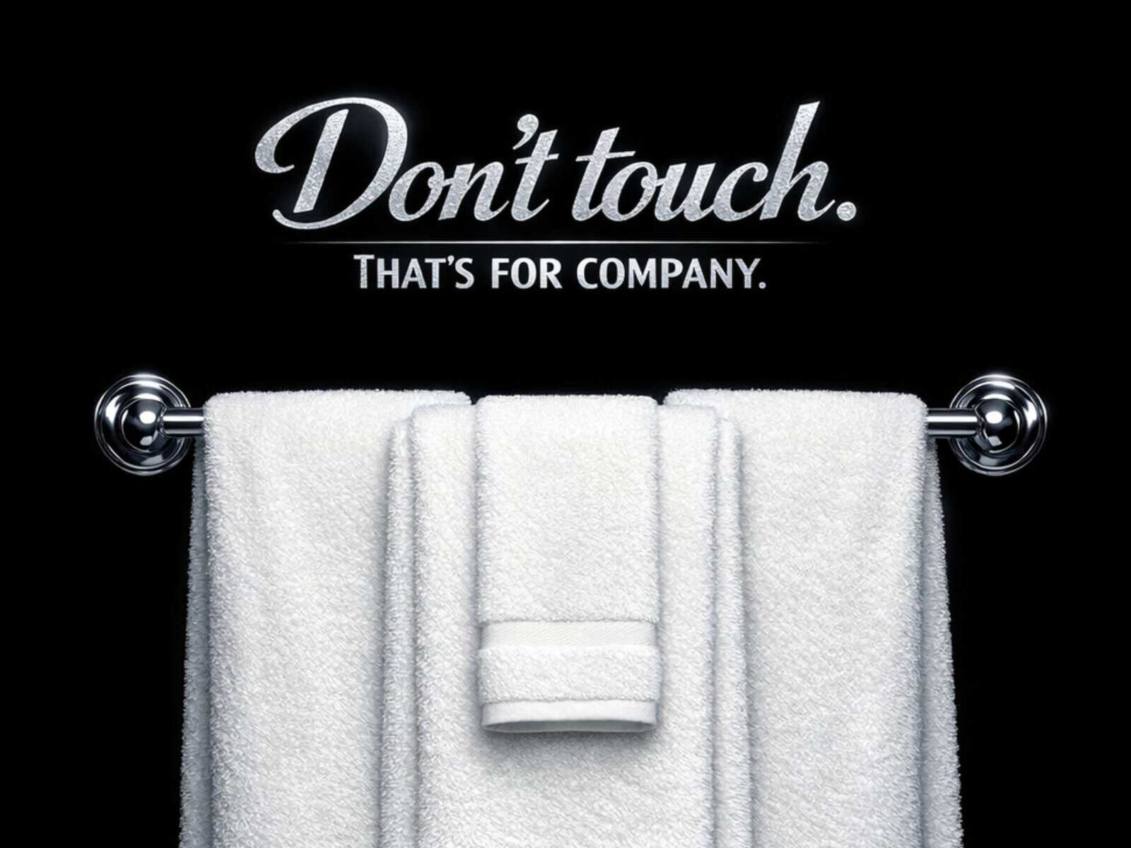 White towel hanging on a towel rack with "Don't touch" sign, black background, for luxury hotel or s.