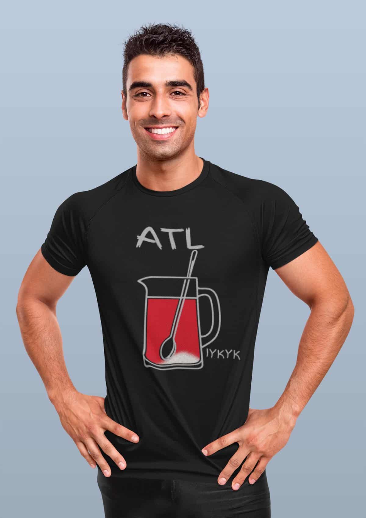Man wearing Atlanta-themed T-shirt with drink illustration outdoors.