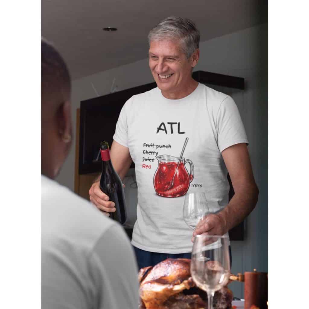 Happy man holding wine bottle and glass at family event.
