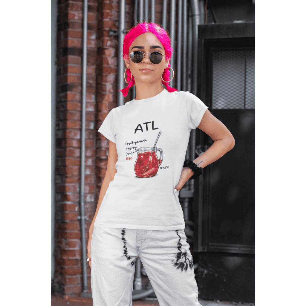 Stylish woman with pink hair, sunglasses, and casual outfit in urban setting.