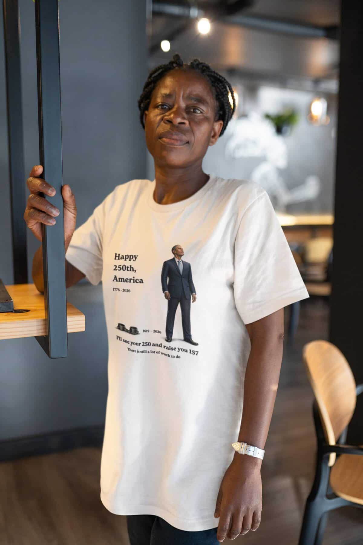 Woman wearing a T-shirt celebrating America's 250th anniversary in a modern cafe.