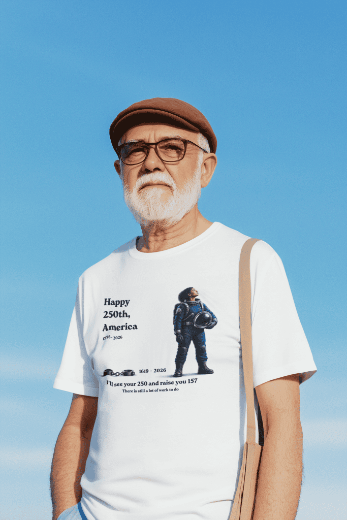 Elderly man with white beard wearing a commemorative T-shirt celebrating America's 250th anniversary.