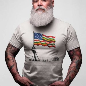 Man with gray beard wearing a patriotic American flag T-shirt, standing confidently.