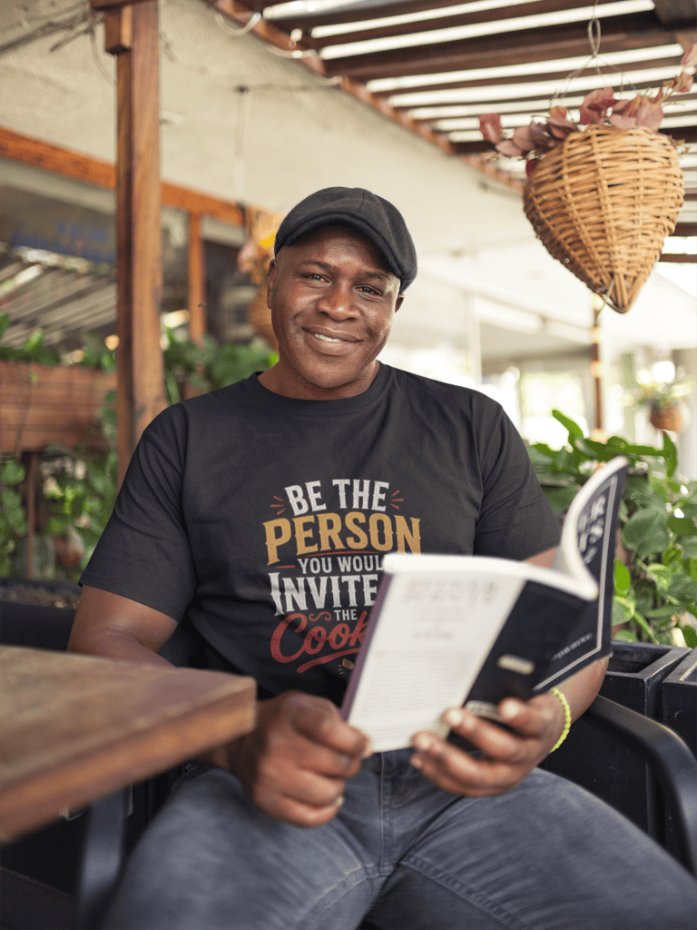 Smiling man in casual attire reading menu at cozy cafe setting.
